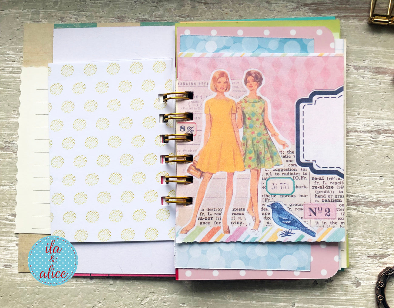 Planner with colorful pages featuring vintage-style illustrations on a wooden surface.