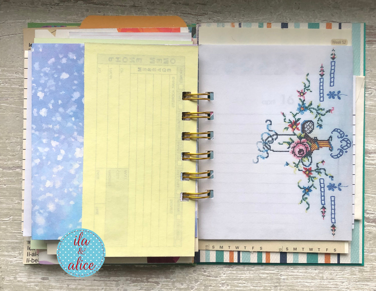 Planner with floral design on a wooden surface, featuring the brand 'ila & alice'.