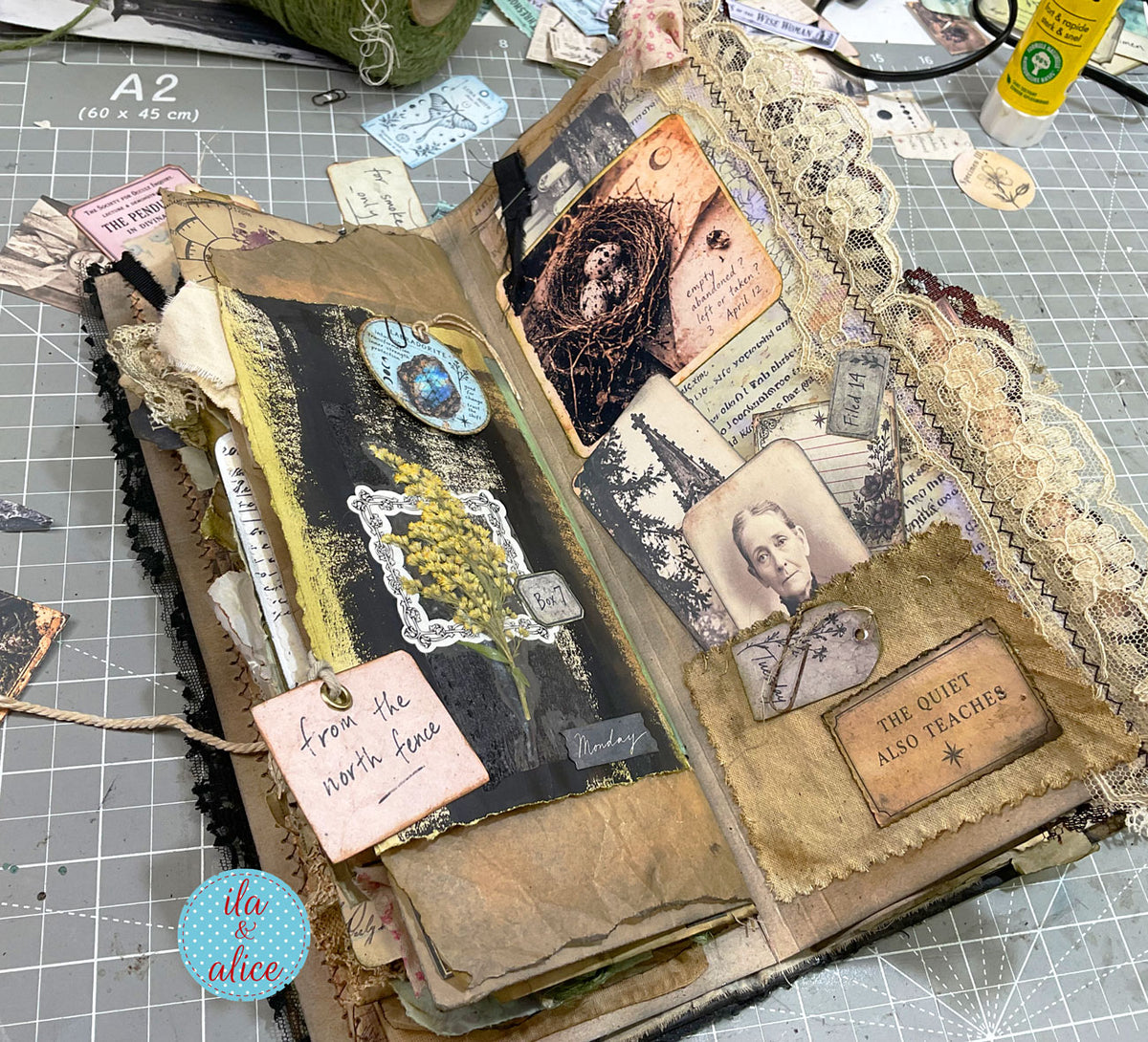 Layered grimoire journal pages with dried flowers, vintage photographs, handwritten notes, aged fabric, lace and found-object style ephemera.